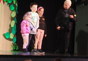 Dzieci na scenie teatru w obecności aktorki