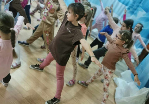 Dzieci ćwiczą krótką choreografię.