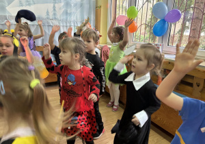 Dzieci w strojach karnawałowych uczestniczą w zabawach z balonem