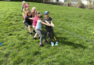 Dzieci przeciągają linę w ogrodzie przedszkolnym