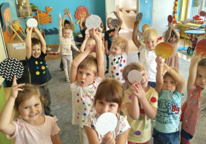 Dzieci trzymają w rękach kolorowe kropki.