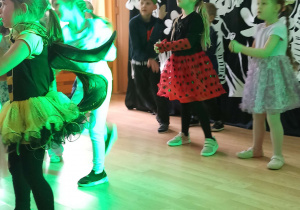 Dzieci przebrane w stroje "wiosenne" tańczą na alu Wiosny