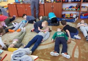 Dzieci z grupy podzielone są na 2 zespoły. Dzieci symulują osoby wymagające nagłej pomocy i osoby udzielające pomocy. Kilkoro dzieci sprawdza oddech , leżących na dywanie kolegów.
