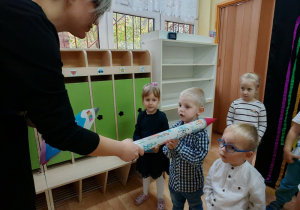 Pani Wicedyrektor dotyka dużą kredką ramienia chłopca.